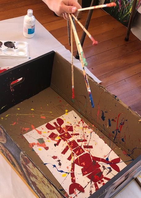 Image showing a paint being splashed onto a collage in one of Art Spark's children's art classes